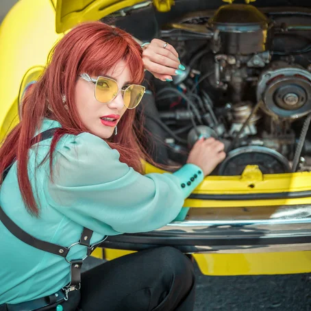 Vrouw bij auto met open motorkap