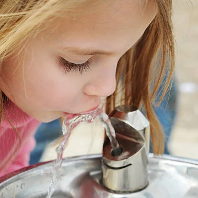 Meisje drinkt uit kraantje