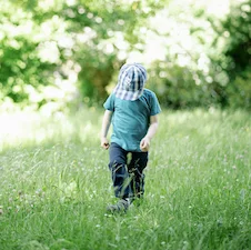 Kind loopt door grasveld